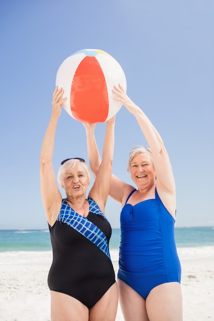 Senior woman holding beach ball