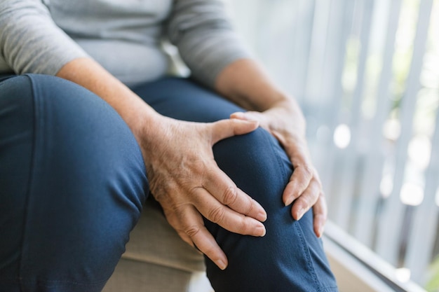 Photo senior woman holding her painful knee