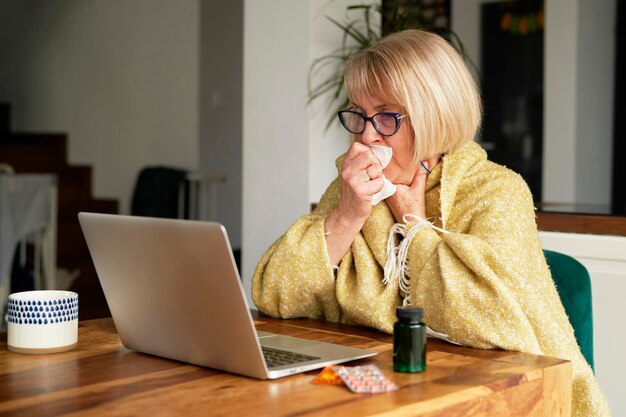 Senior woman is sitting in front of the computer