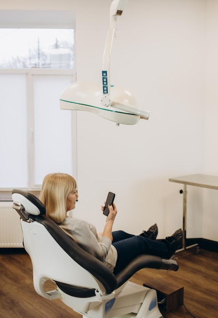 Senior woman is waiting for a doctor using a mobile phone