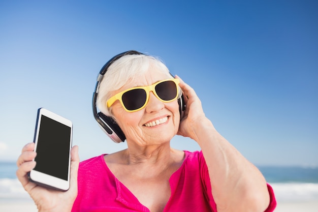 Senior woman listening music with headphone