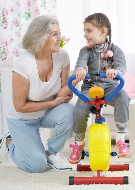 Senior woman and little granddaughter doing exercise