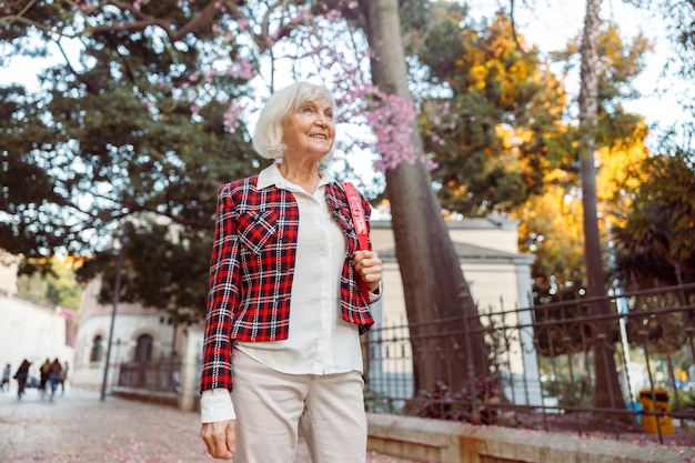 Senior woman looking away while standing in city