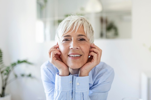 Senior woman looking at camera. Successful mature business woman. Happy old professor with gray hair.