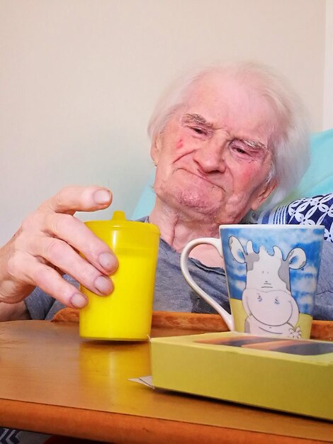 Senior woman looking at drink in home