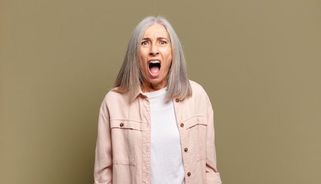 Senior woman looking shocked, angry, annoyed or disappointed, open mouthed and furious