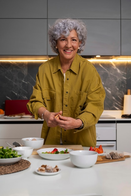 Foto senior donna che fa il piatto con i fichi in cucina