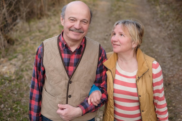 Senior woman and man walking in park