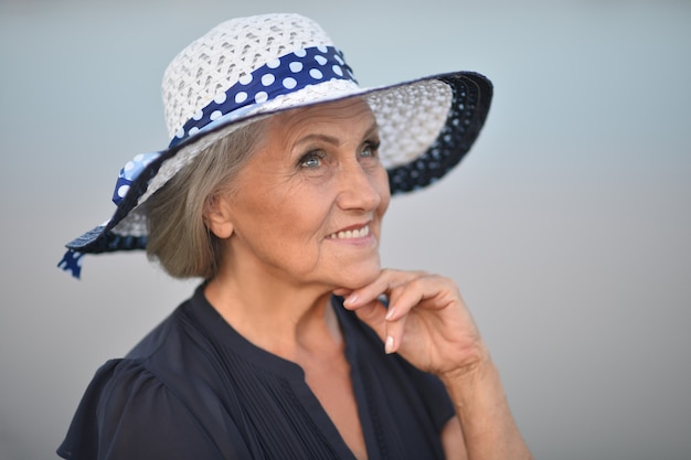 Senior woman   near lake in  summer,blurred background