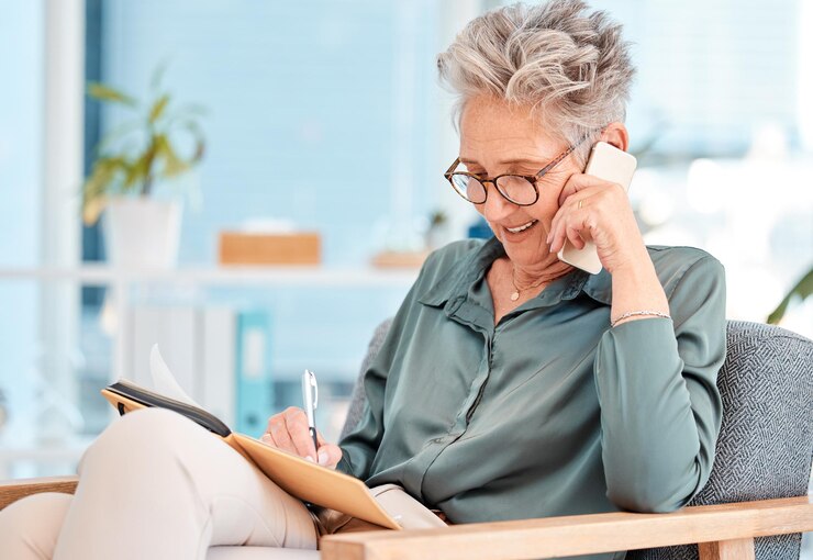 Senior woman office call and ceo phone communication of a consulting lawyer writing a schedule Working phone call and elderly legal worker talking about a corporate strategy and law firm vision