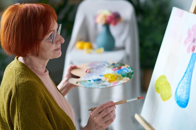 Senior woman painting still life