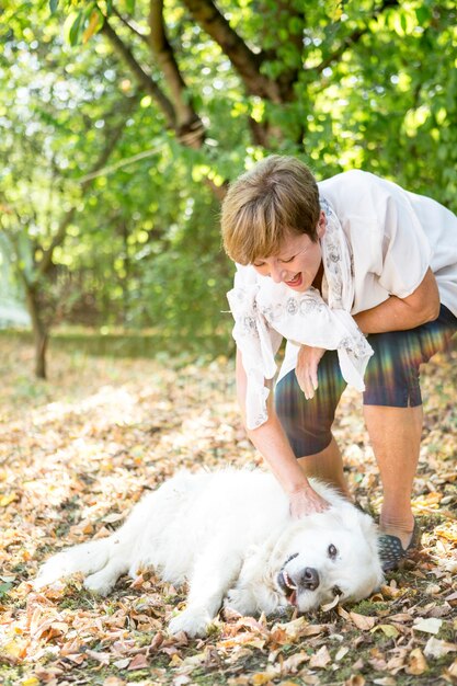 Senior woman petting dog outdoors