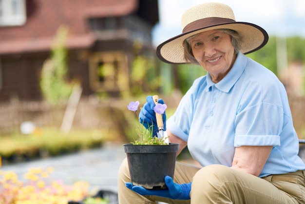 Старшая женщина, посадка цветов