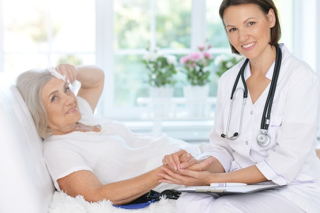 Senior woman portrait in hospital with caring doctor