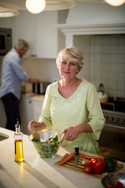 Photo senior woman preparing vegetable salad