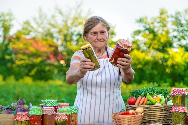 Senior woman preserving vegetables in jars Selective focus