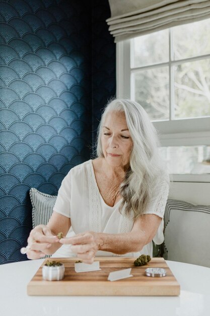 Senior woman rolling a weed joint