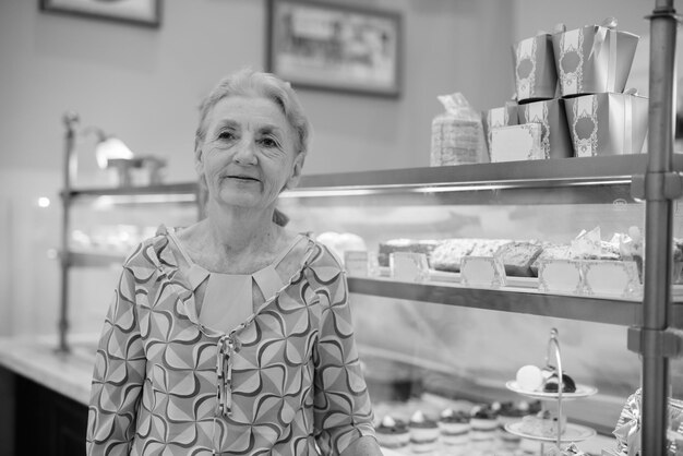 Фото Пожилая женщина стоит в торговом магазине.