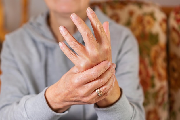 Senior woman suffering from hand and finger joint pain inflammation