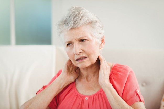 Senior woman suffering from neck pain at home