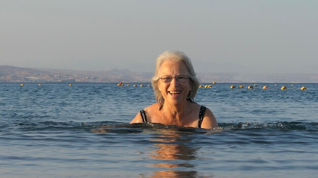 Foto donna anziana che nuota in mare