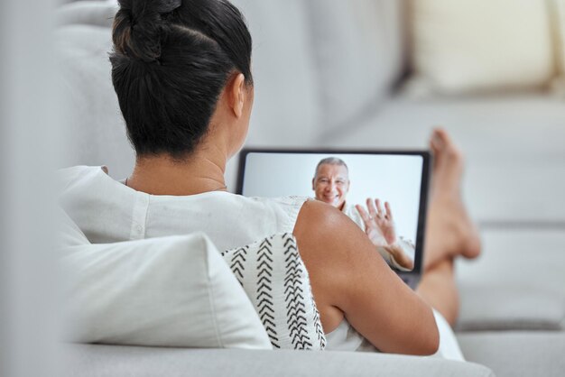 Foto donna anziana e tablet per videochiamata sul divano con uomo marito o amico su internet in casa coppia divano e videoconferenza in soggiorno con fidanzato o coniuge felice sullo schermo in casa