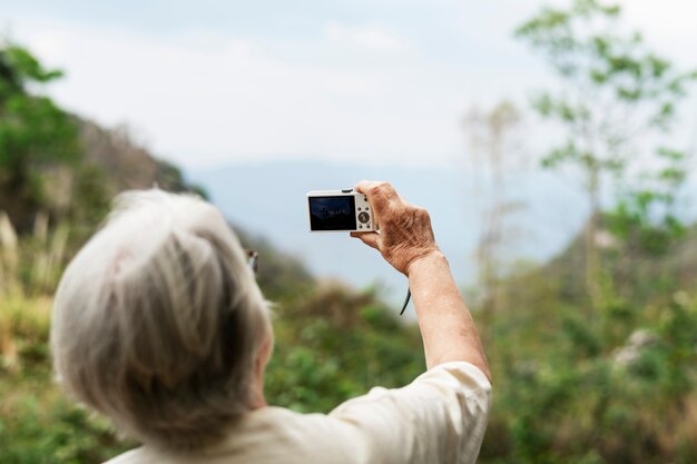 年配の女性が眺めの写真を撮る