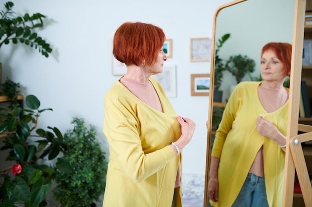 Senior woman trying on new cardigan