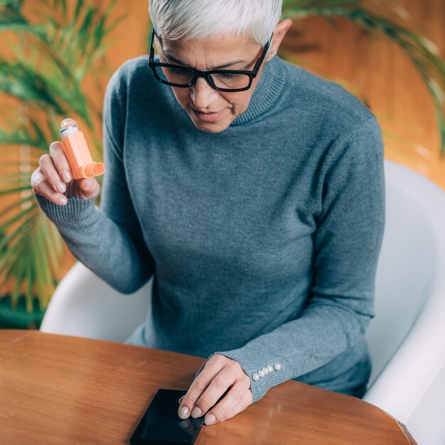 Photo senior woman using inhaler