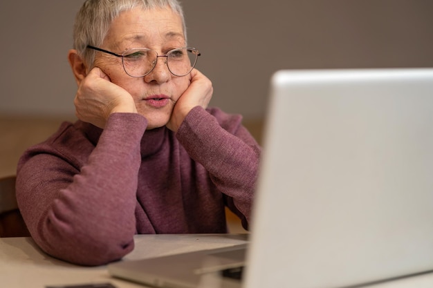 Foto donna anziana che usa il portatile a casa