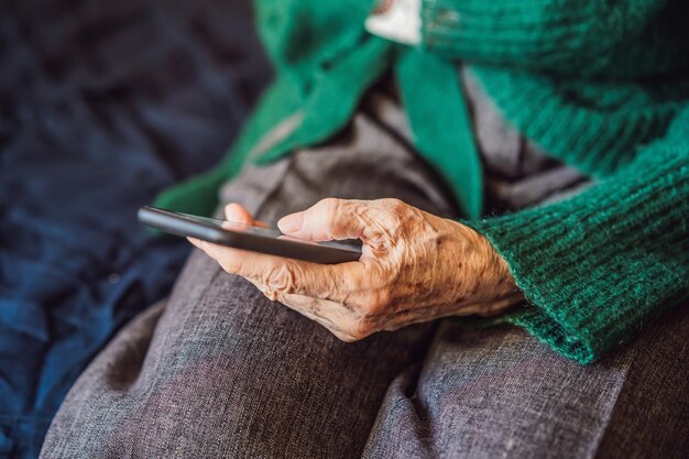 Senior woman using mobile phone while sitting on sofa