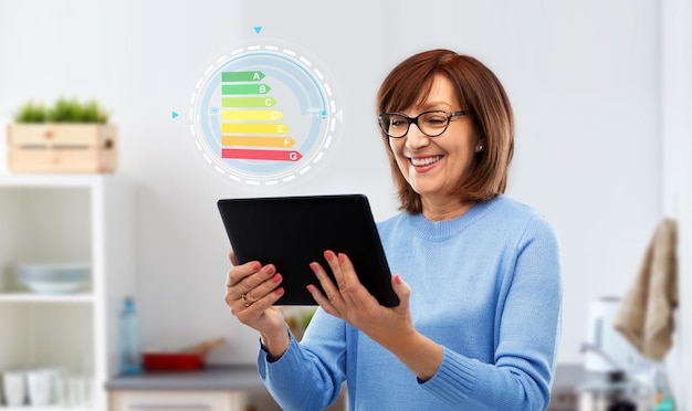 Photo senior woman using tablet pc with energy chart