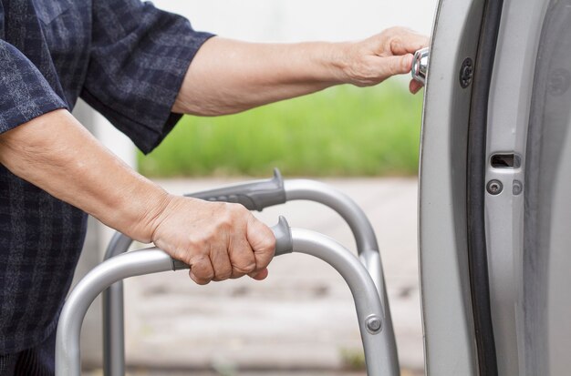 Senior woman using a walker at car park