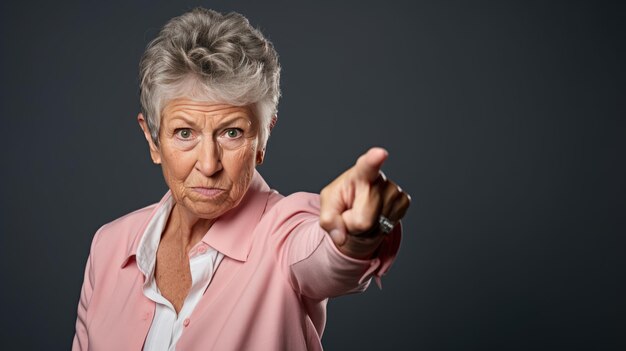 Senior woman wearing casual clothes pointing with hand and finger to the side looking at the camera