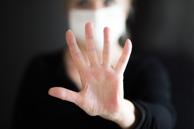 Фото Старшие женщины носить маску, показывает чистые руки и показать стоп руки. выборочный фокус.