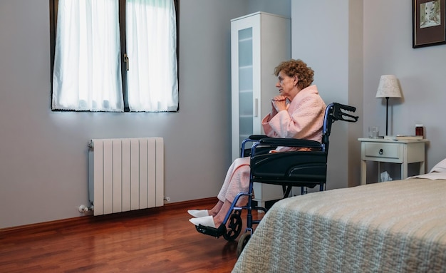 Senior woman in a wheelchair alone in a room