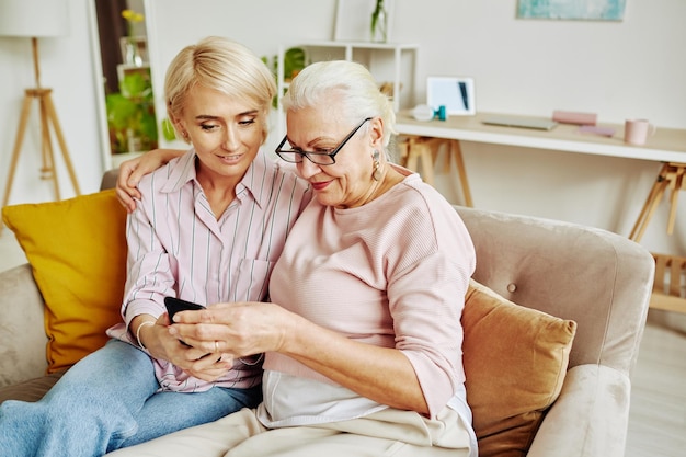 Senior Woman with Adult Daughter using Smartphone