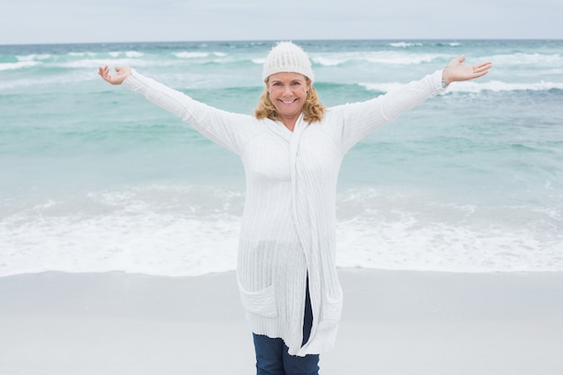 Foto donna maggiore con le braccia tese in spiaggia