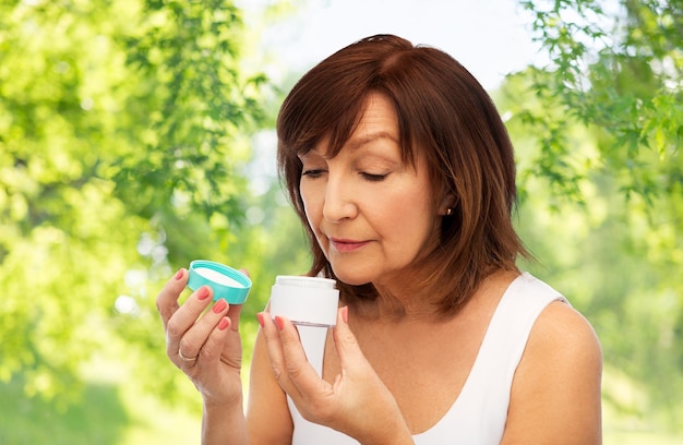 Photo senior woman with cream jar