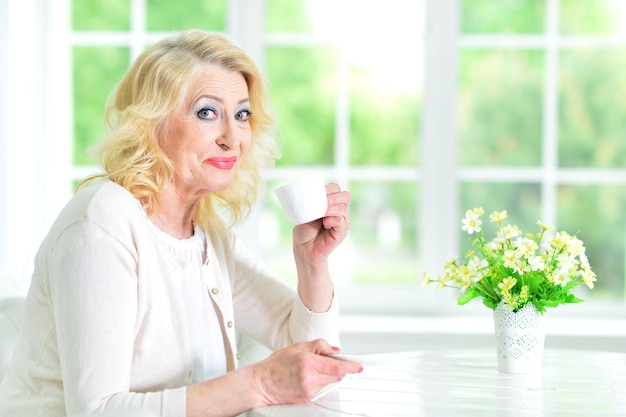 お茶のカップを持つ年配の女性