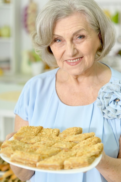 おいしいクッキーを持つ年配の女性