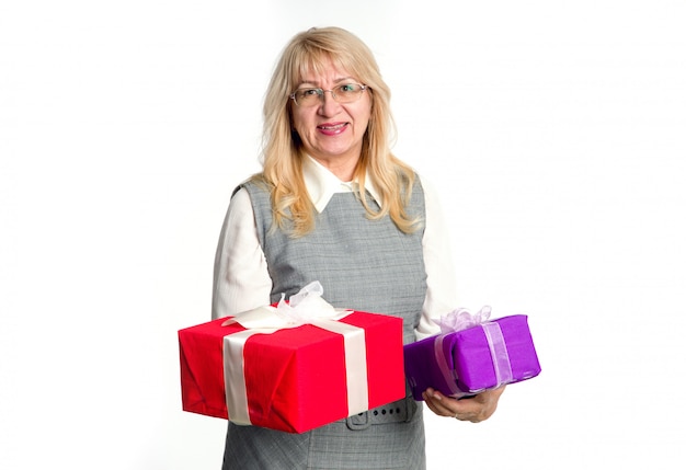 Senior woman with gifts boxes in her hands on a light background.