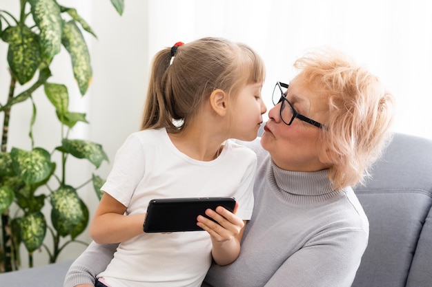 スマートフォンでゲームをしている孫を持つ年配の女性。