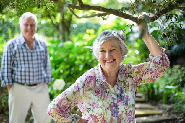 Senior woman with husband standing in background