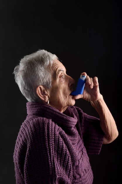 吸入器を持つ年配の女性