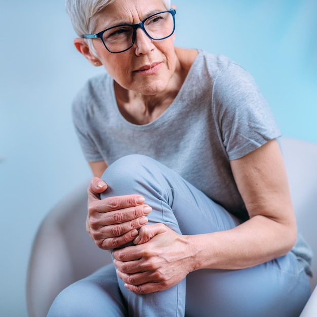 Foto senior donna con dolore al ginocchio