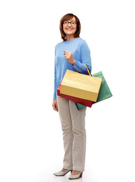 senior woman with shopping bags isolated on white