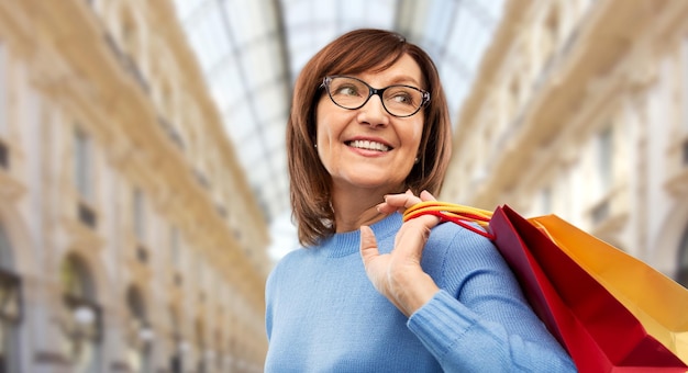 Photo senior woman with shopping bags over mall