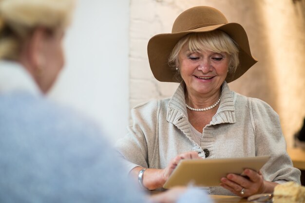 Senior woman with tablet smiling