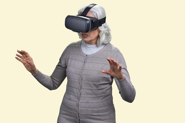 仮想現実のヘッドセットを持つ年配の女性は、vr メガネ o を身に着けている vr 経験老婆に唖然とします。